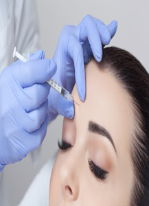 Woman receives a Botox injection in her forehead to minimize frown lines