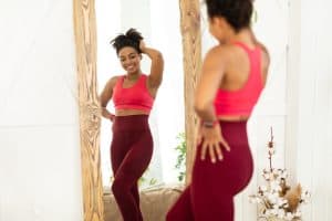 Miami woman looks happy with her body shape in a full length mirror.