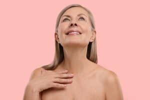 Mature woman lifts her chin to show off sleek neck contours.