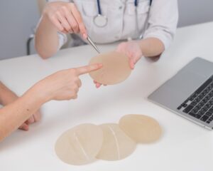 Doctor and patient discuss breast implant revision in a medical practice office
