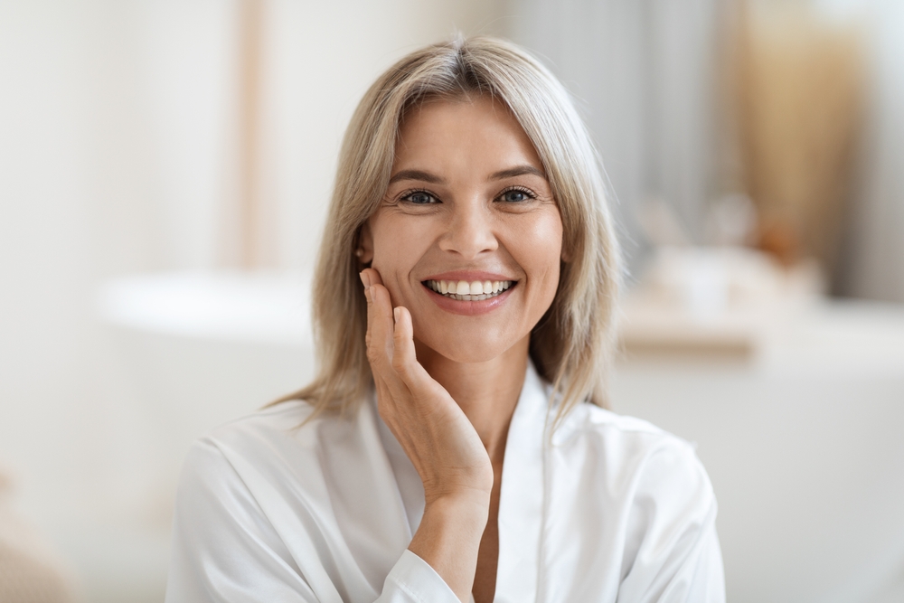 Smiling woman with a refreshed lower face and neck after facelift and neck lift surgery.