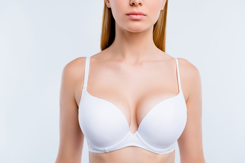 Woman has symmetrical breasts after breast lift made necessary adjustments.