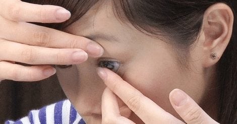 girl putting on contact lens