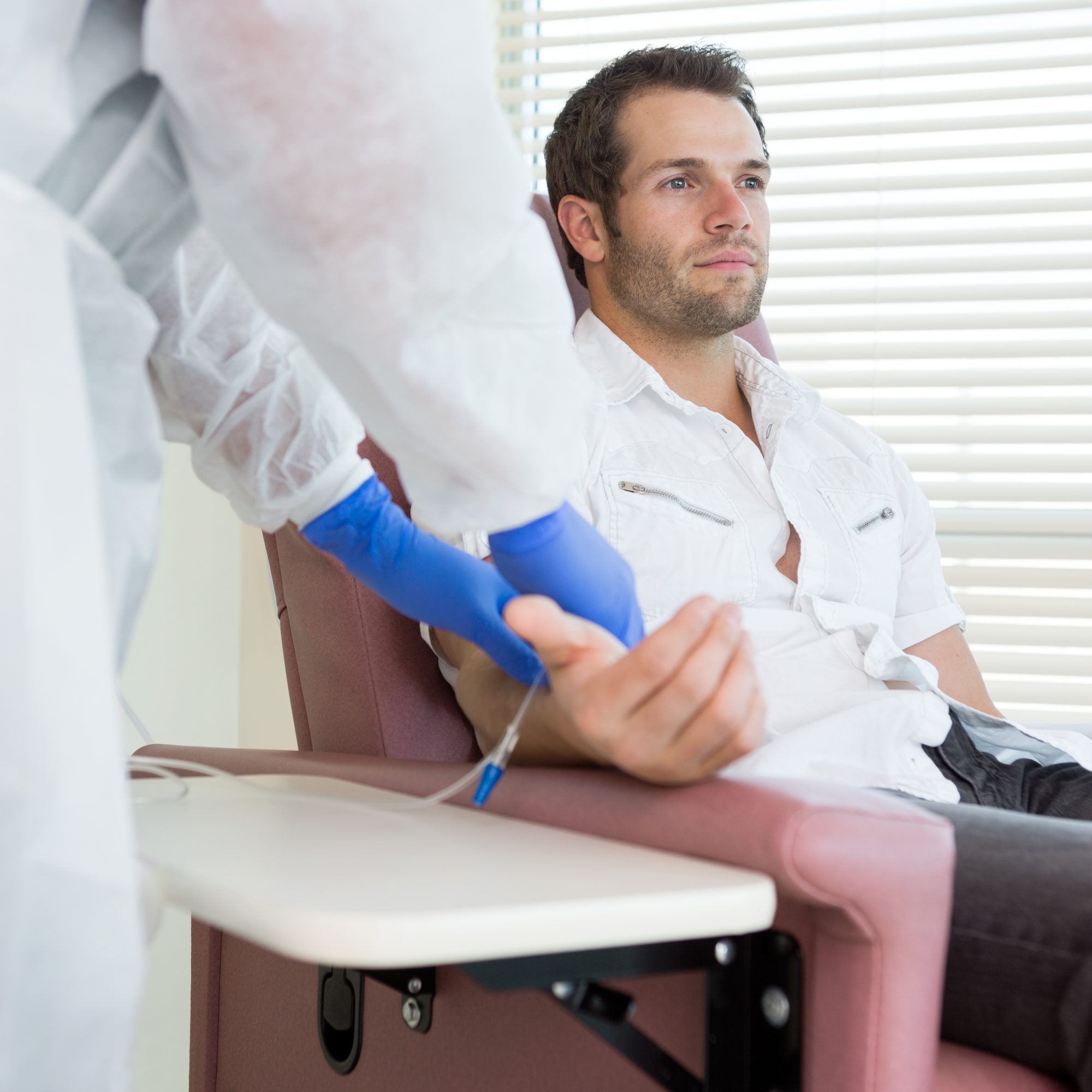 Male patient receives intravenous treatment in chemotherapy room