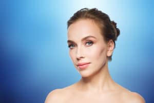 photo of beautiful young woman’s face over blue background