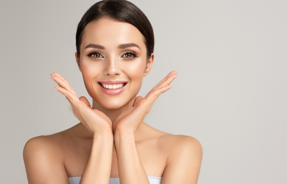 Woman shows off her beautiful smile after cosmetic dental treatments and smile makeover.