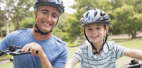 Boy and father biking smiling