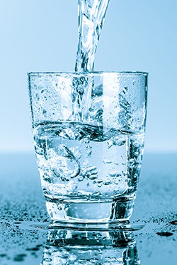 A glass of splashing ice water reminding you to enjoy fresh water on a regular basis.