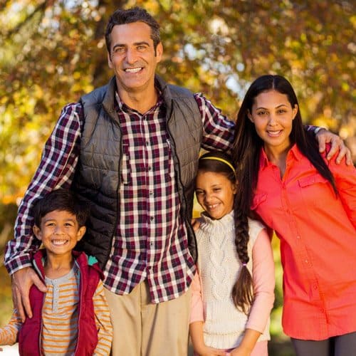 family hugging close and smiling for fall family portrait