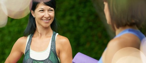 Middle age woman chatting with her friend before yoga