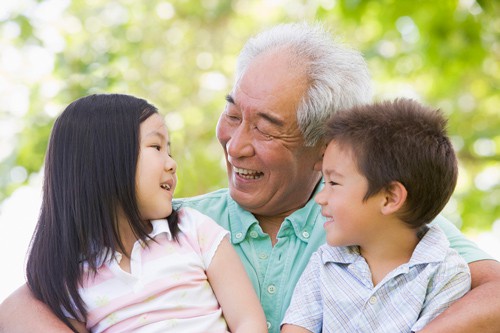 grandpa smiling holding two grandchildren