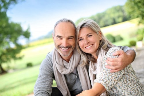 Older couple embracing and smiling outdoors