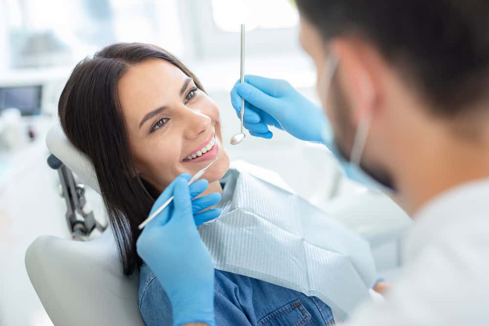 Woman smiling during dental exam to discuss bone loss in Seattle