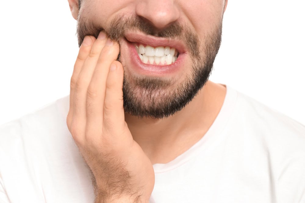 Man with tooth pain holding his jaw