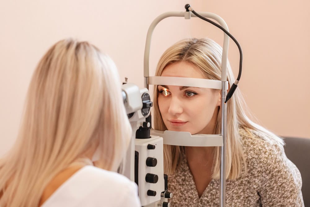 Blonde woman undergoes an eye exam to examine early signs of ocular trouble