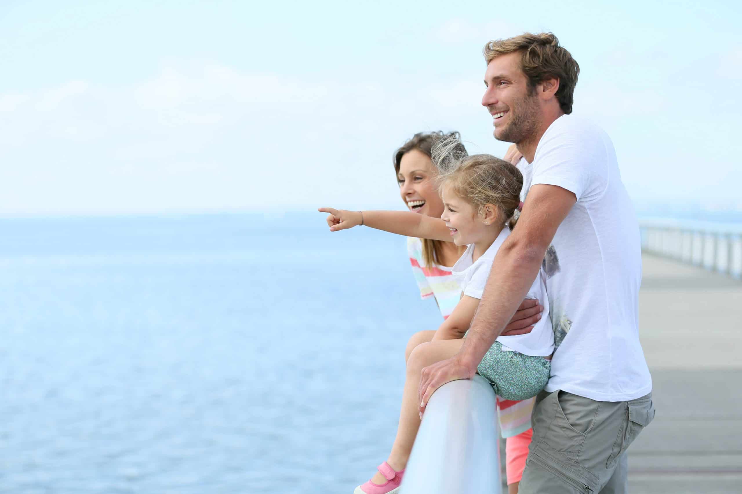 Young family stands on pontoon pointing out at water with clear vision things to ICL