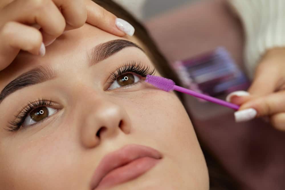 Woman has eye makeup applied, which may accidentally contribute to dry eye.